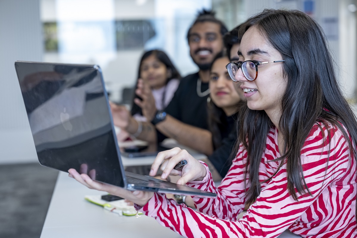 Mixed group of students using a laptop to collaborate